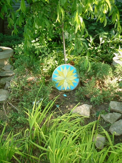 A yellow and blue compass rose amidst green plants